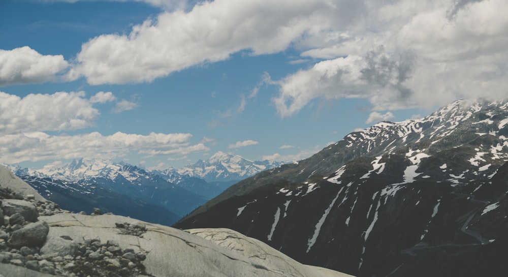 snow capped mountains under blue and white cloudy sky