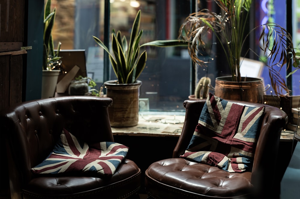 two brown leather couches beside glass window