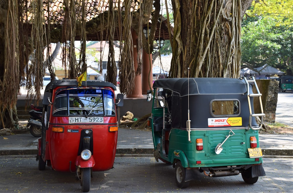 two assorted-color auto rickshaws parked on sidewalk