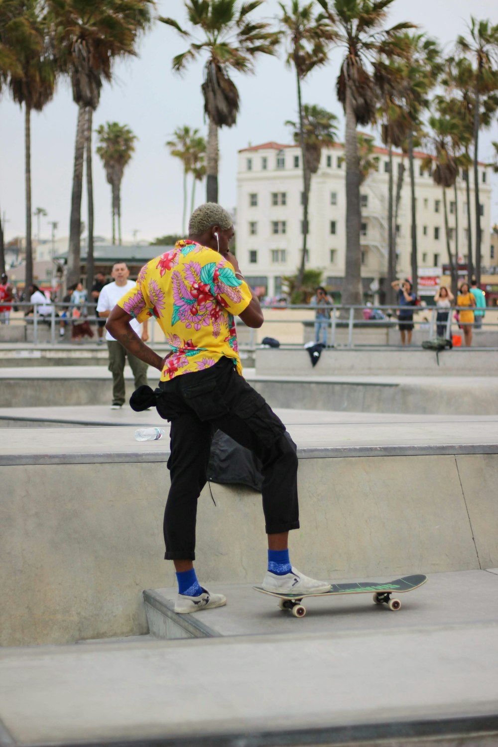 man stepping on black skateboard on park