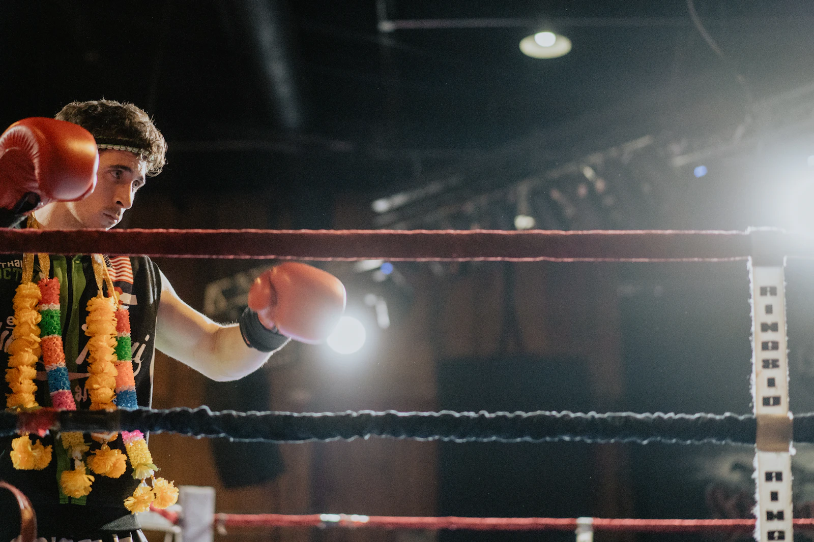 A fighter wearing a mongkol headband in the ring before a fight