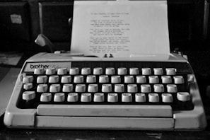 A vintage typewriter with a glossy finish on a wooden desk.