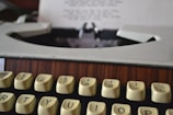 A close-up of a vintage typewriter on a wooden desk.