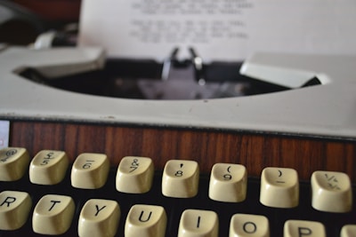A close-up of a vintage typewriter on a wooden desk.