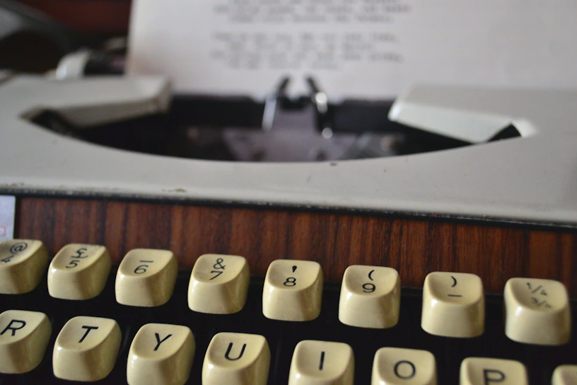 A vintage typewriter close-up with an old newspaper background texture.