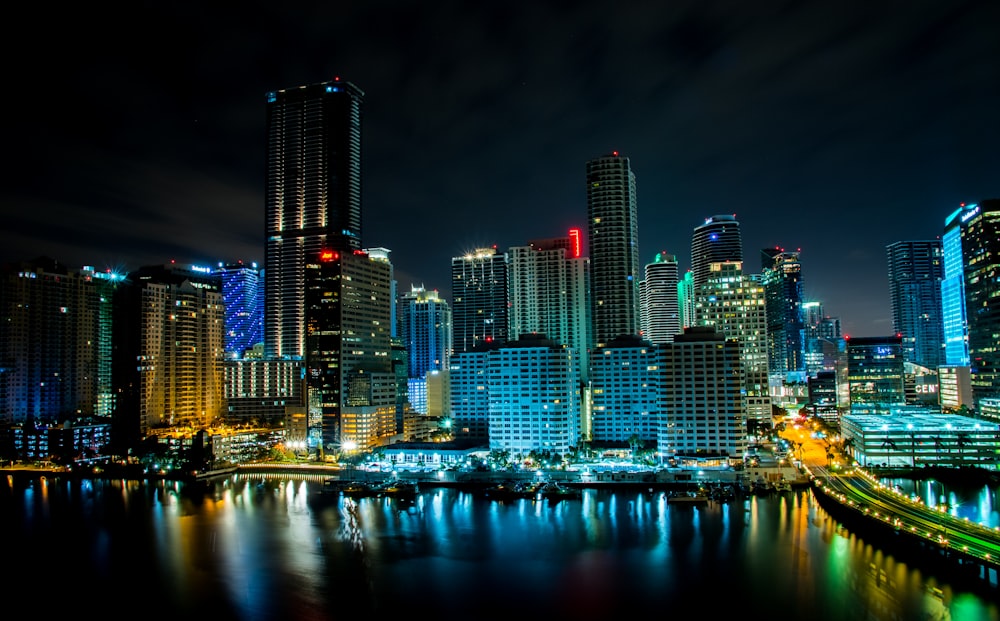 edifício iluminado perto do corpo de água durante a noite