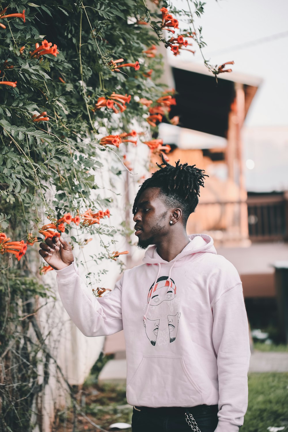 man holding trumpet creeper flowers in bloom