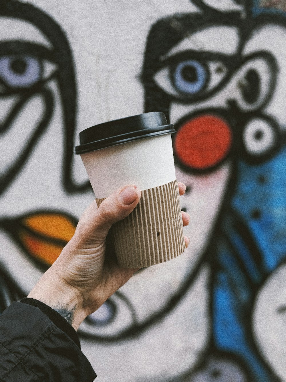 person holding white paper cup