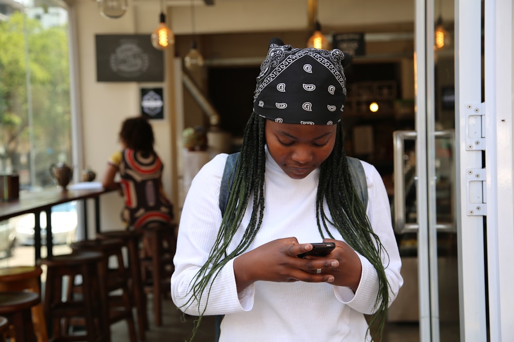 woman standing while holding black phone