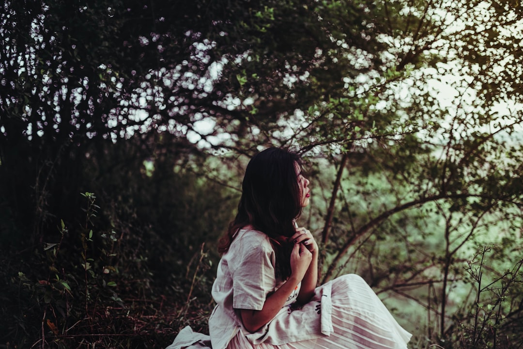 woman sitting beside tree