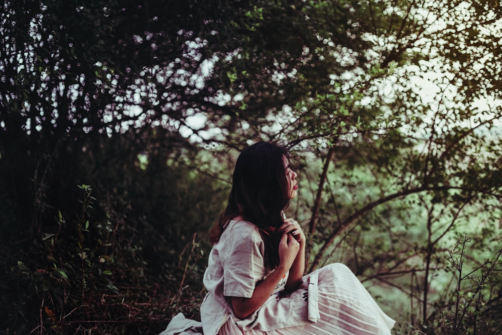 woman sitting beside tree