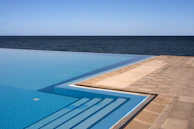 Infinity pool blending seamlessly with the ocean horizon under a clear blue sky.