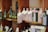 Several shelves display a variety of olive oil bottles. The bottles are in dark and light colors, with some wrapped in decorative packaging with tags. The shelves are wooden, and the setting appears to be a specialty or gourmet shop.