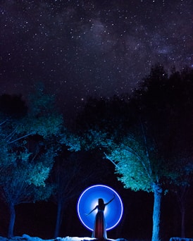 woman in dress standing in between trees