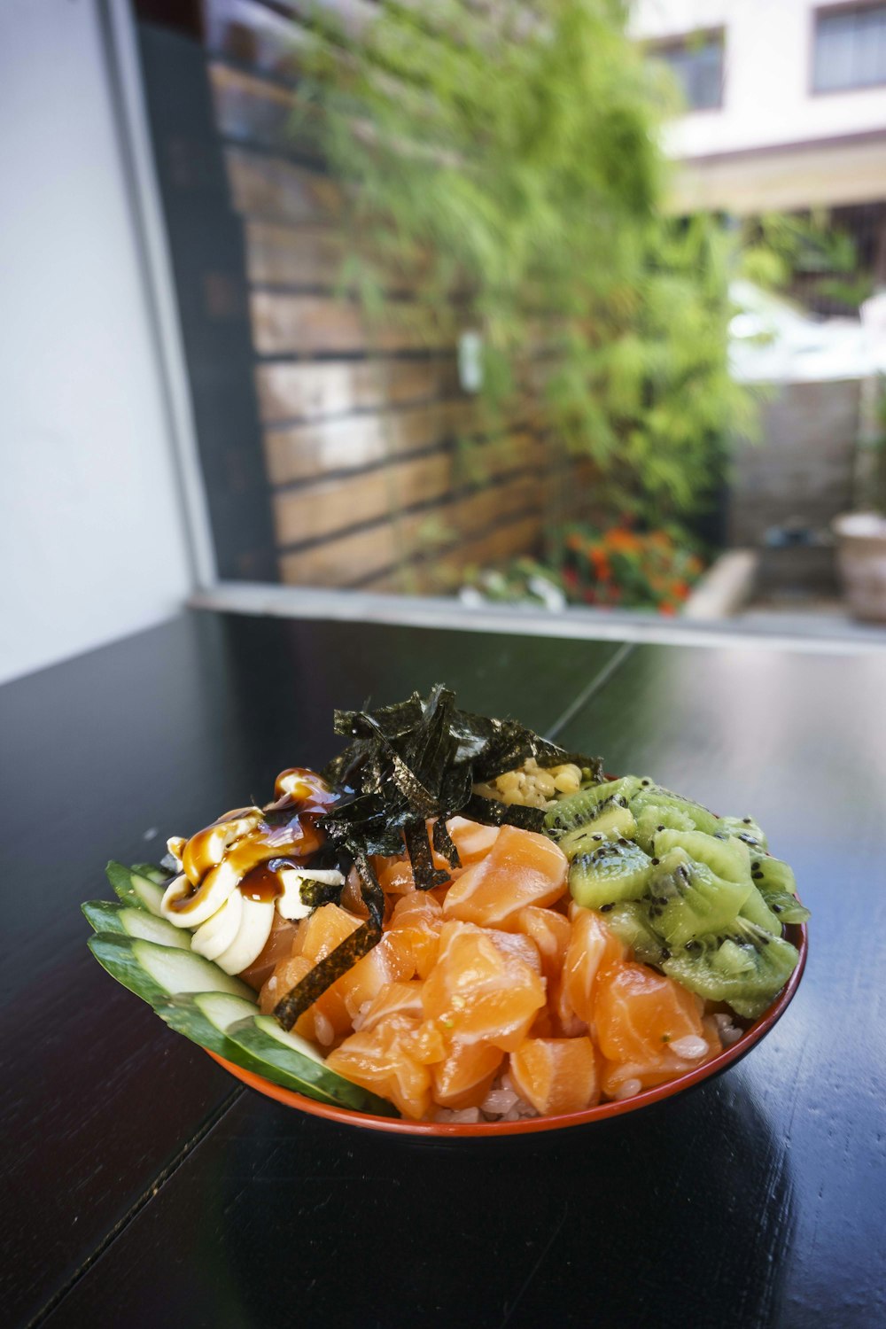kiwi, cucumber, fish meat, banana, and nori salad on plate