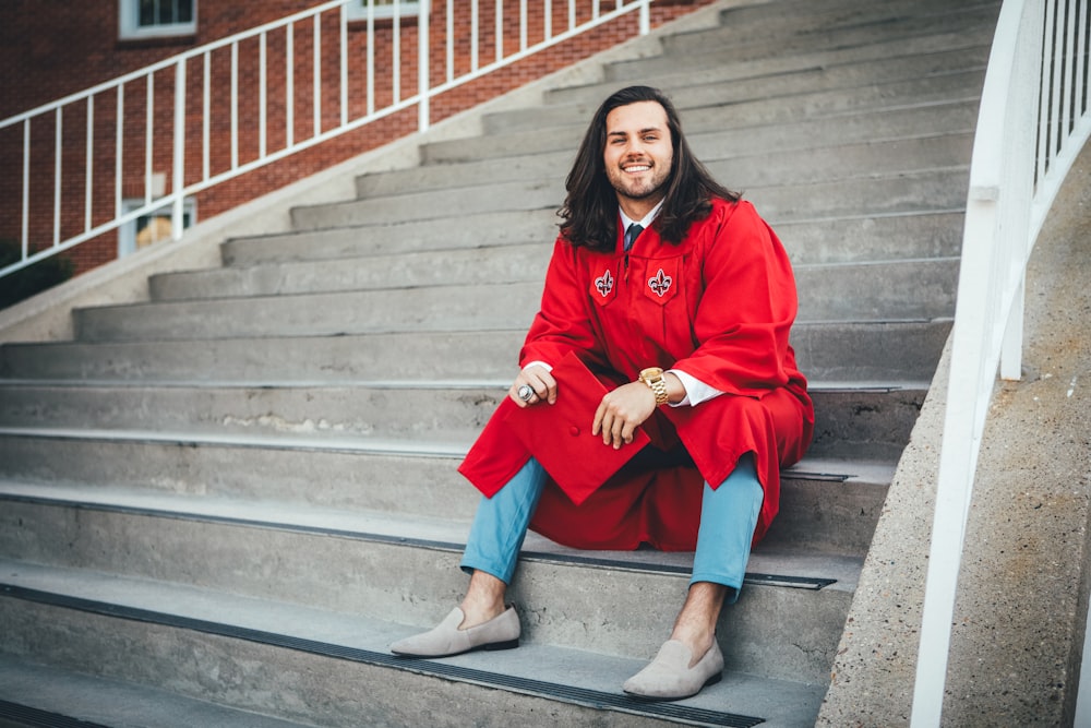 a man in a red coat sitting on some steps