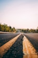 gray asphalt road in between trees