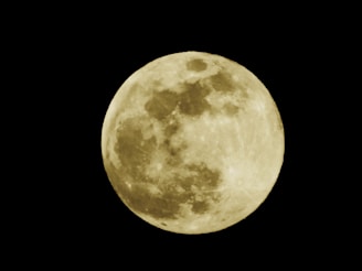 A bright full moon against a dark night sky, showcasing detailed lunar surface patterns and craters.