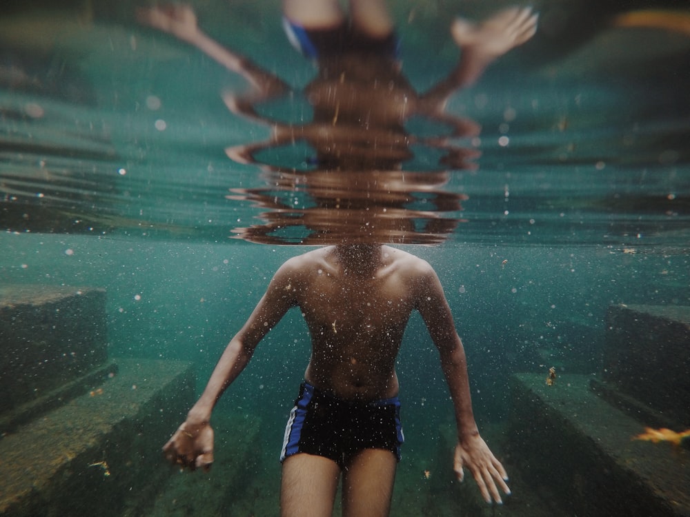 man swimming in body of water