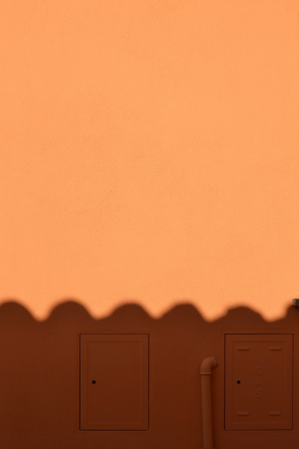 an orange wall with a clock on it
