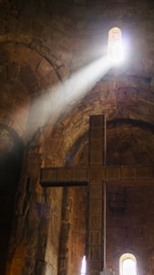 Sunlight streaming through stained glass windows inside a warm, inviting church sanctuary.