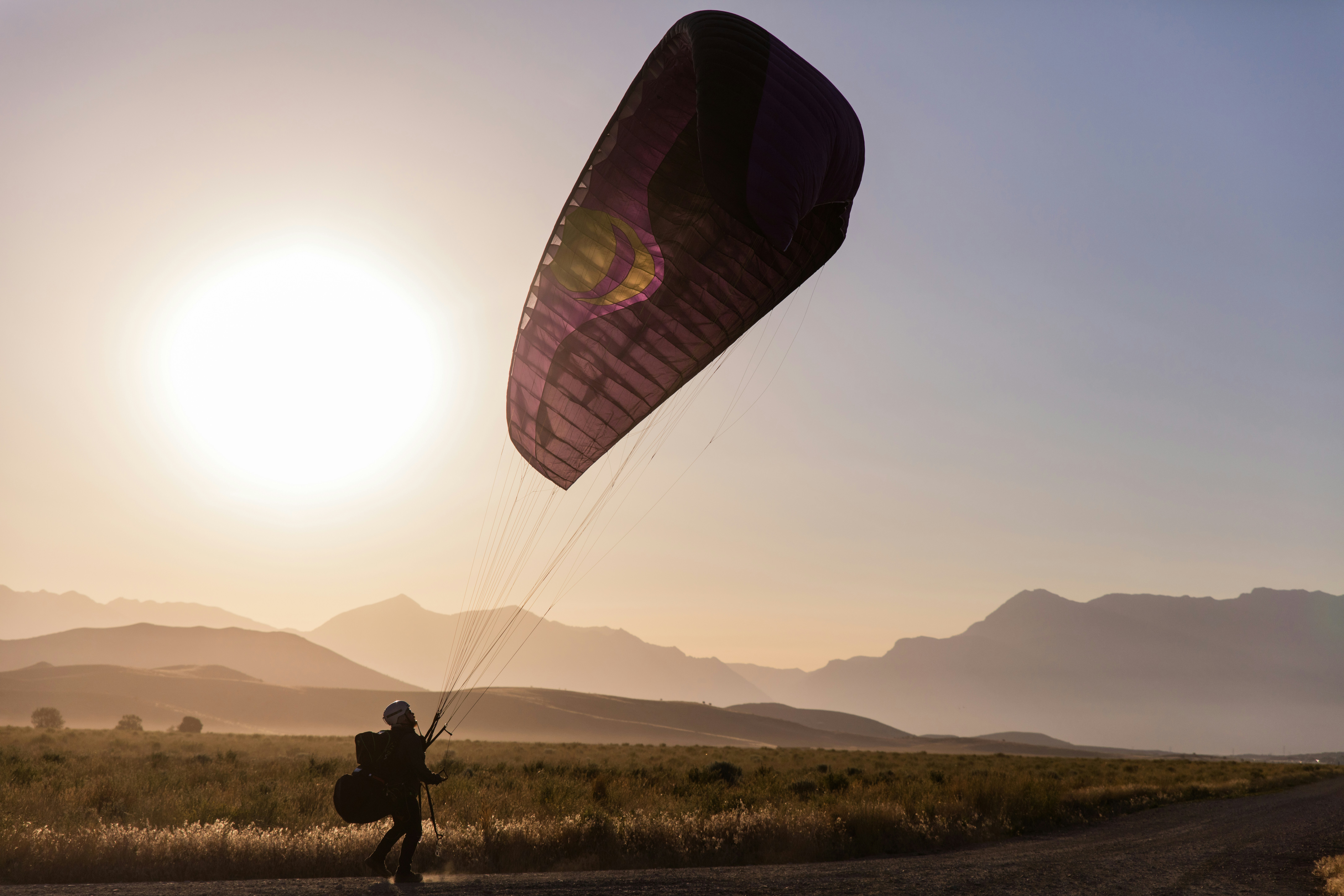 person in black jacket and pants riding on parachute during daytime