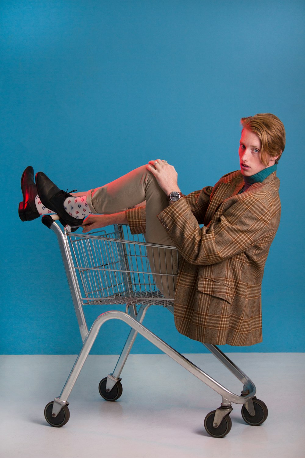 man in brown jacket sitting in shopping cart
