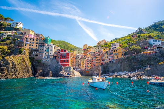 blue fishing vessel near houses on mountain in Parco Nazionale delle Cinque Terre Italy