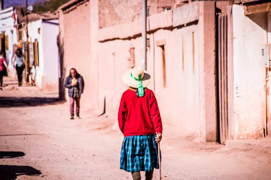 woman walking on gray road in San Pedro de Atacama Chile