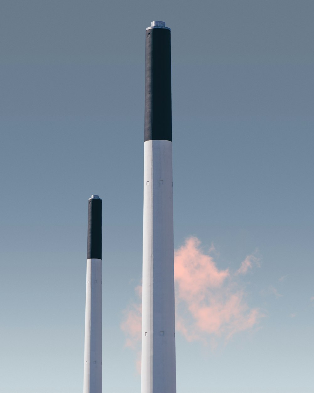 Zwei weiß-ad-schwarze Pfosten unter blauem Himmel