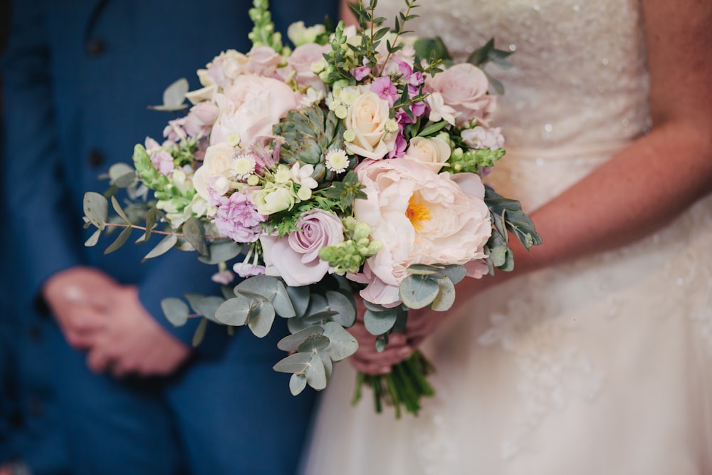 mariée tenant un bouquet de fleurs blanches et roses