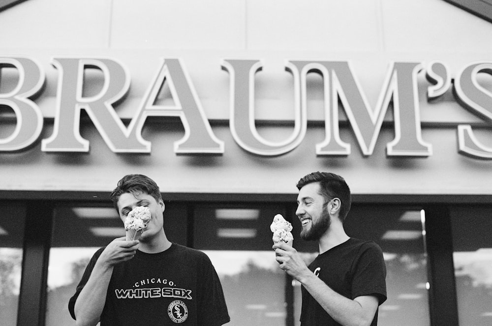 two men eating ice cream grascale photo