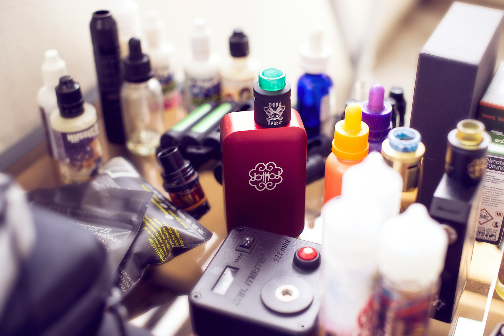 Quick shot of my table while we setup the photoshoot for our website Vapeblog. In the center, you can admire my fresh new electro box from dotmod along with a bunch of eliquids.