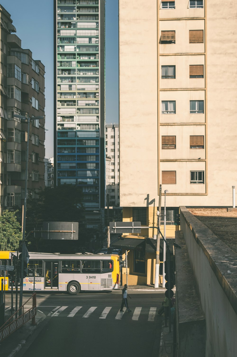 gray bus near beige wall paint high-rise building