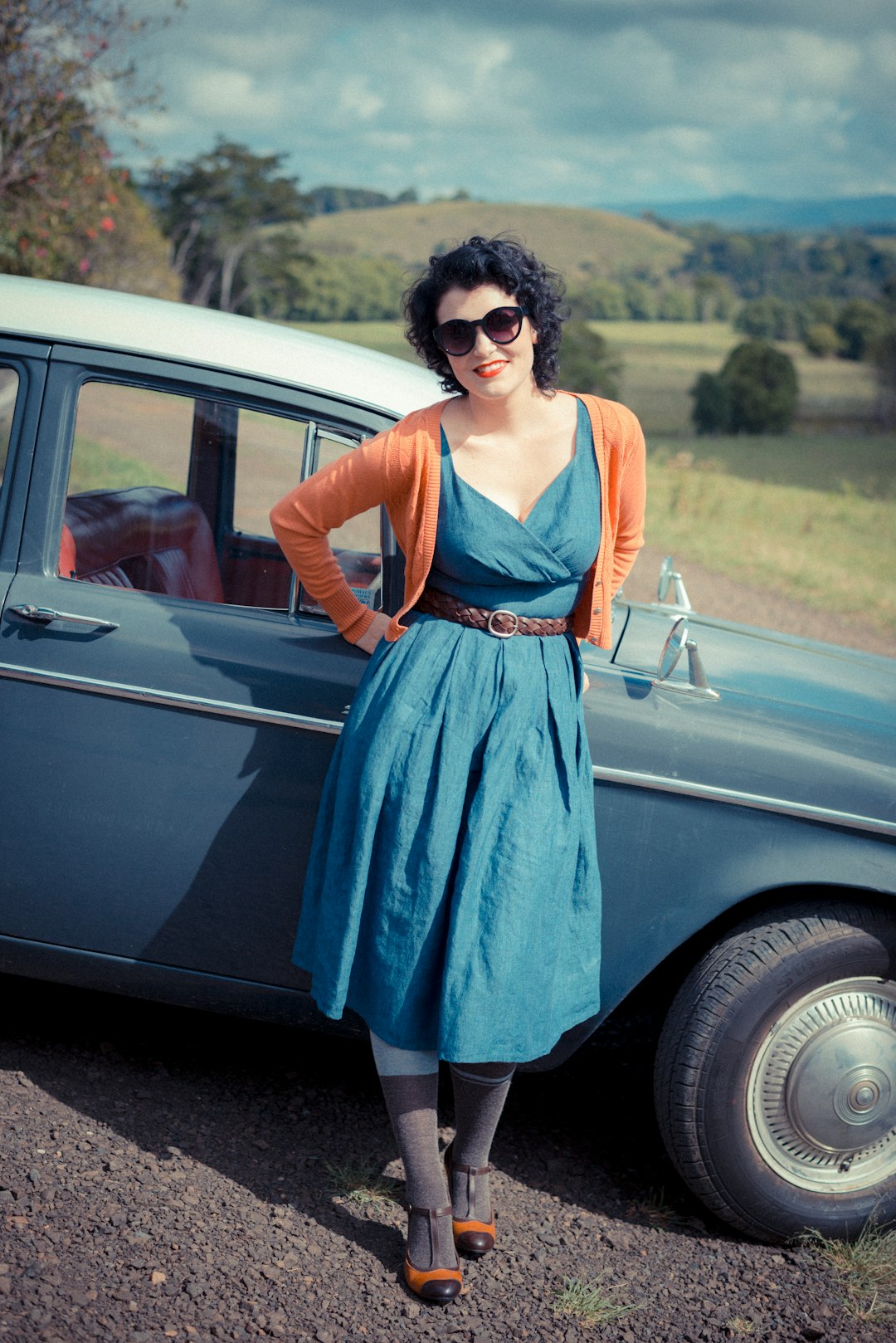 woman leaning on blue car