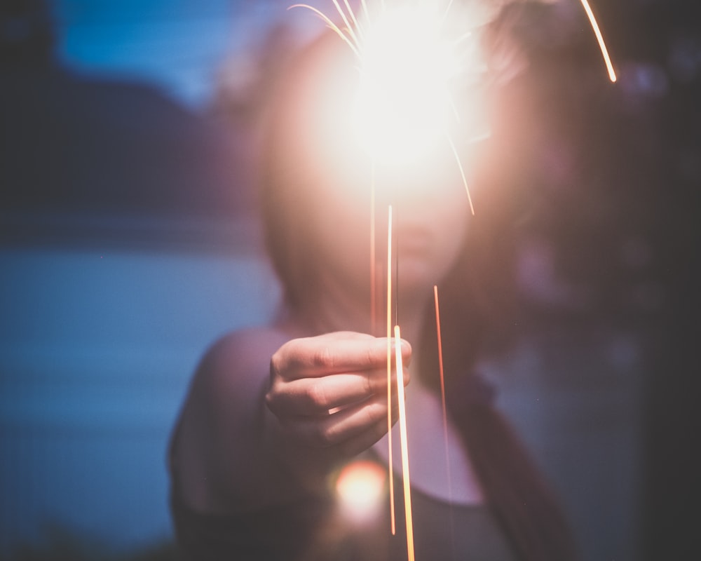 woman holding sparkler during nighttime