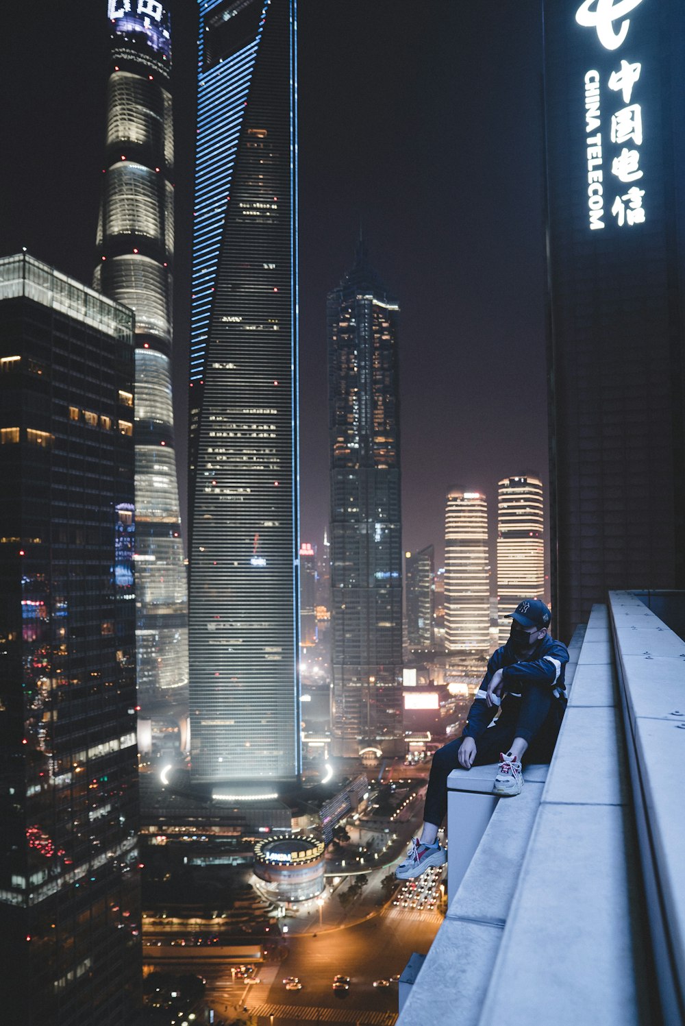 밤에 건물 배수로에 앉아있는 남자