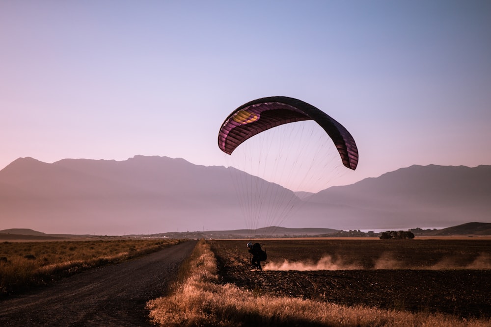 person paragliding on field during daytime