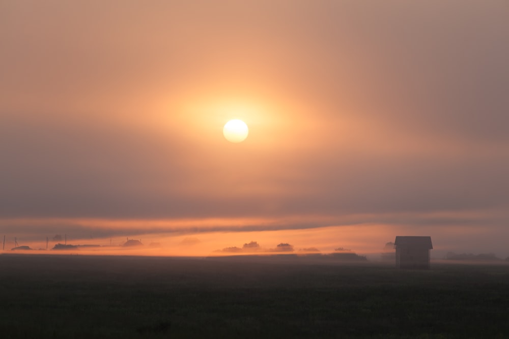 silhouette of house on field at golden hour