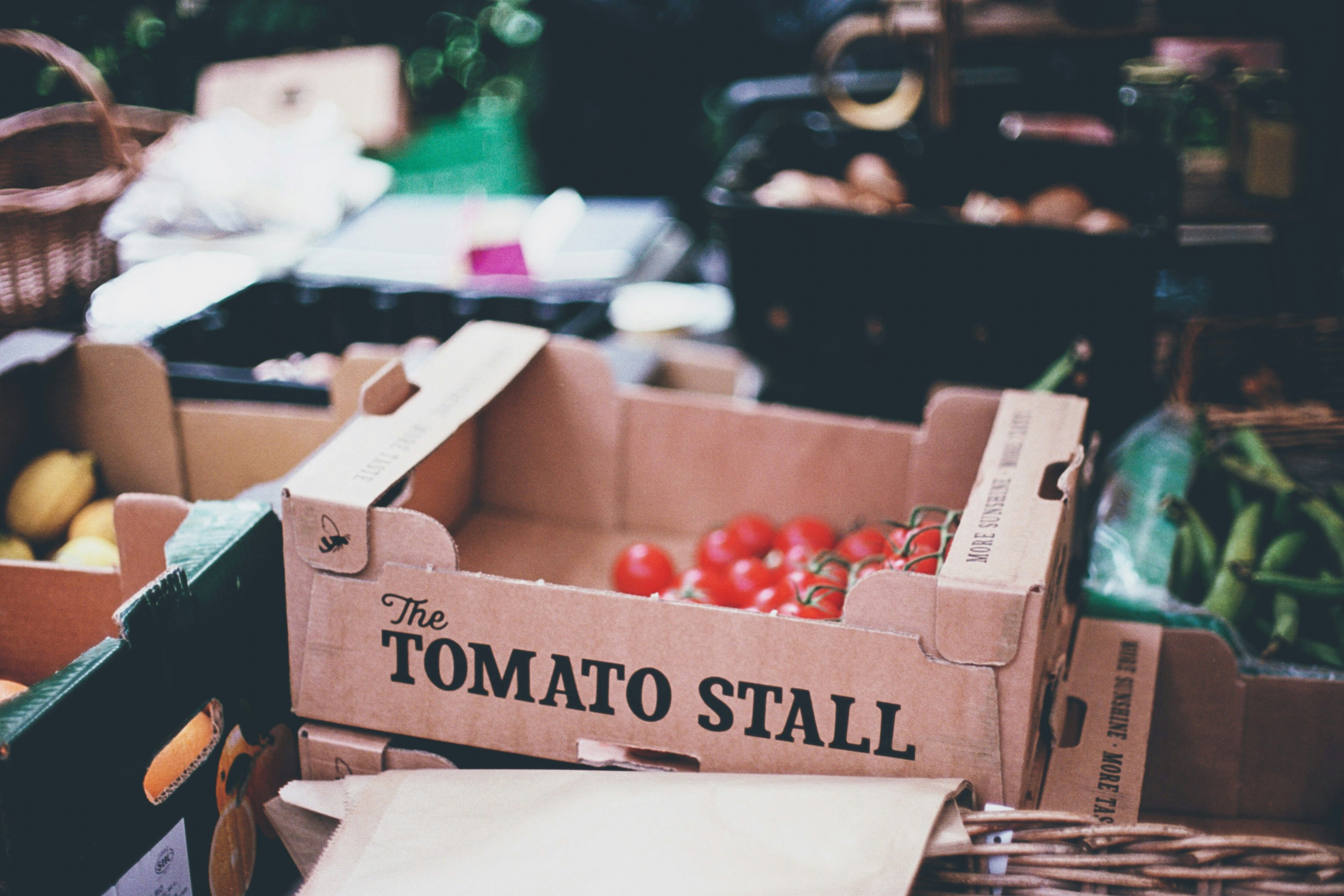 selective photography of tomato stall box on crate