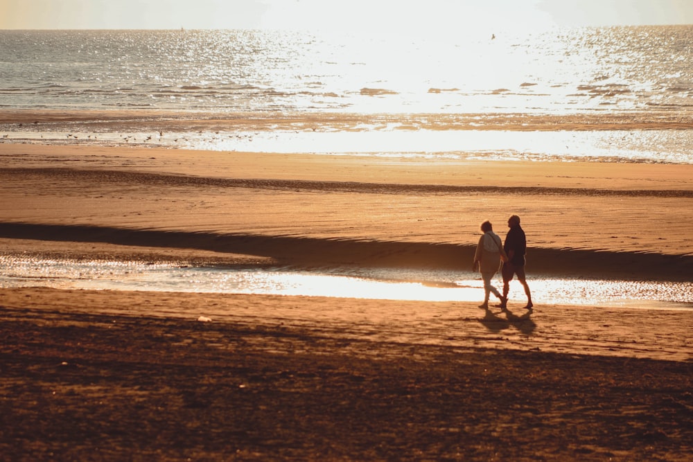 zwei Personen zu Fuß am Strand