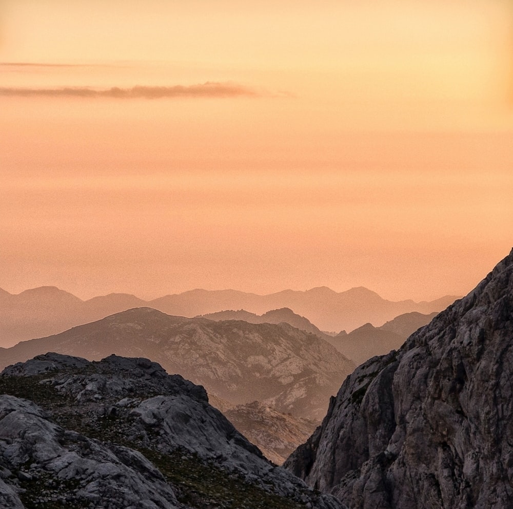 mountain range under cloudy skies