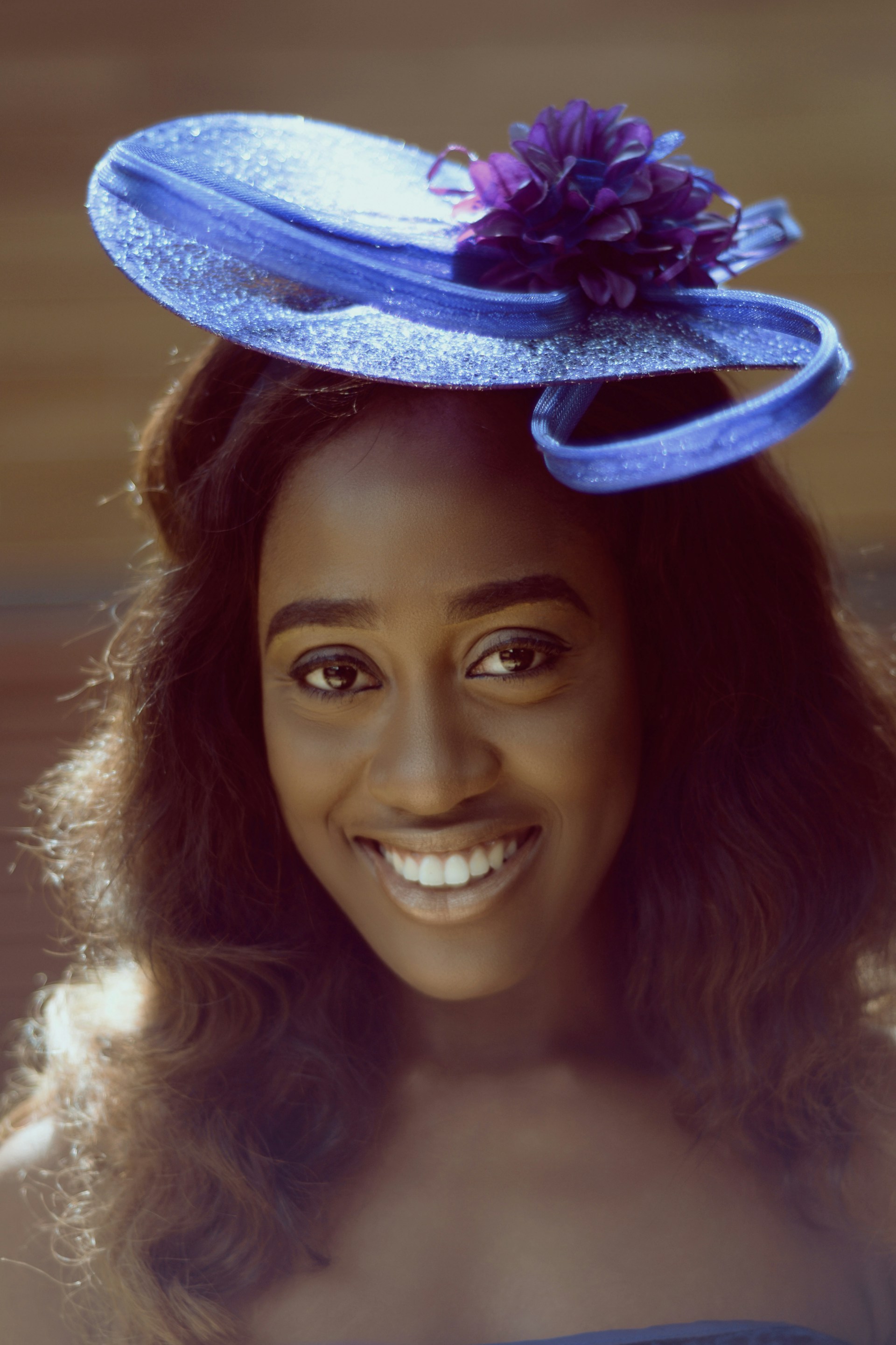 A candid backstage moment showing Regal Rhythm adjusting a Maria Antoinette-inspired headpiece, with hints of avant-garde British fashion and a welcoming smile.