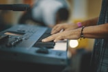 Close-up of guitar and keyboard hands playing together in a cozy studio.
