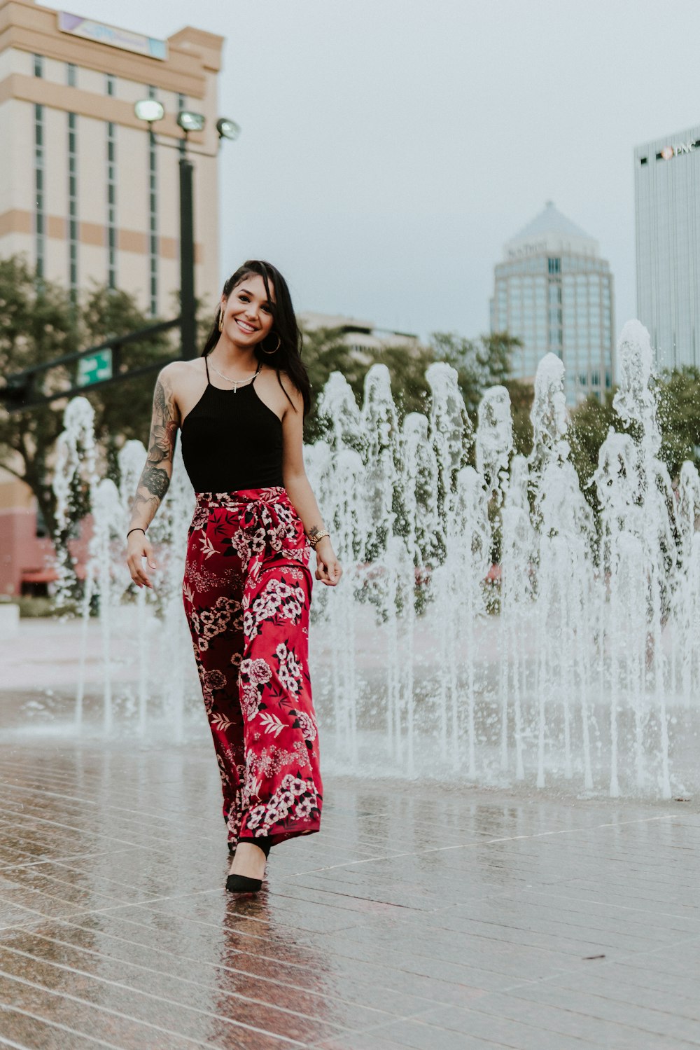 femme souriante debout près de la fontaine