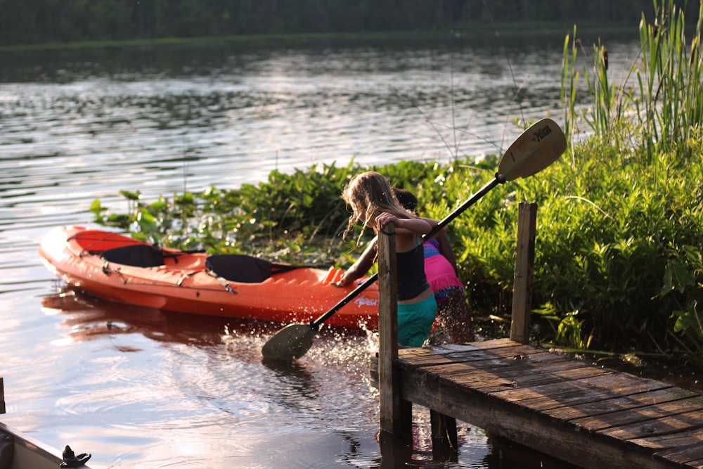 Dos chicas cerca de Orange Kayak en el río