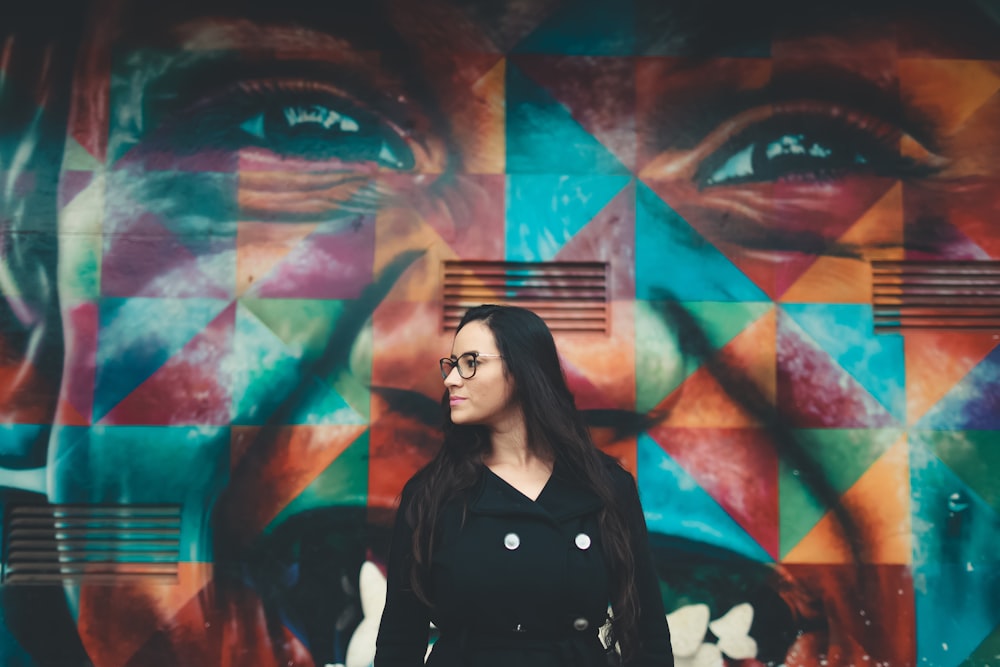 Frau steht in der Nähe einer Graffiti-Wand