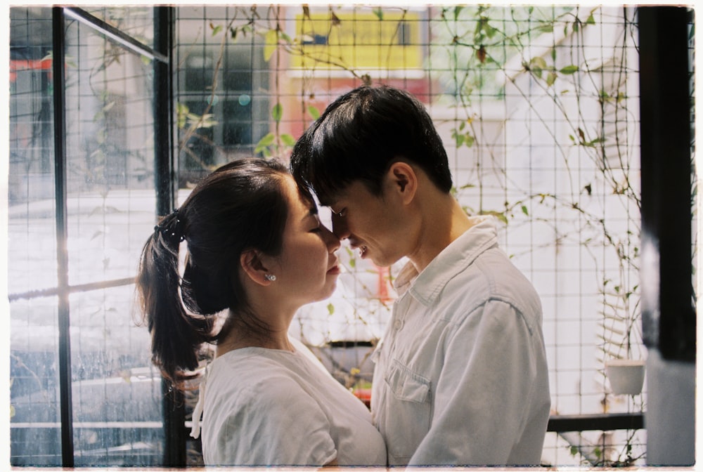 couple facing each other standing near fence