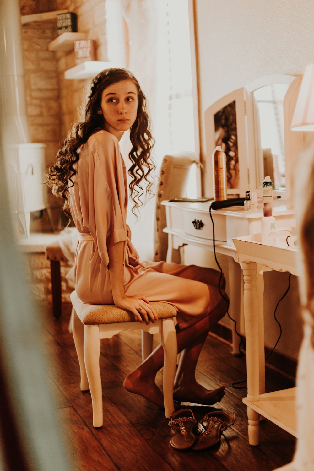 woman sitting in front of vanity table