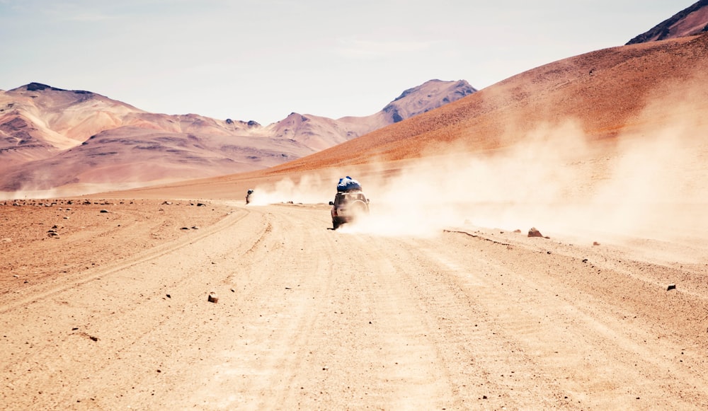 car traveling on brown soil